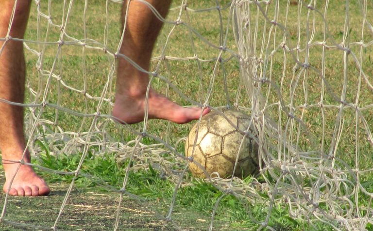 Füße und ein Ball aus Leder. Fußball.