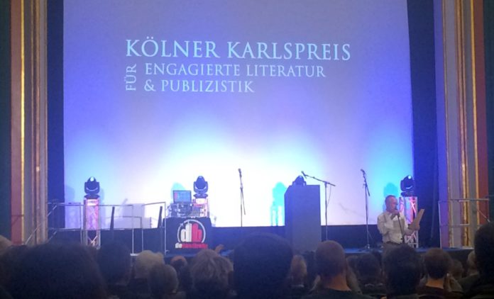 Timothy Grossman spricht auf der Preisverleihung mit dem Titel "Kölner Karlspreis für engagierte Literatur und Publizistik" im Kino Babylon.